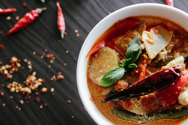 Comment préparer un curry rouge thaï avec du lait de coco et des légumes croquants ?
